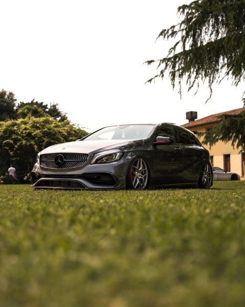 Una Mercedes grigia ribassata sul prato