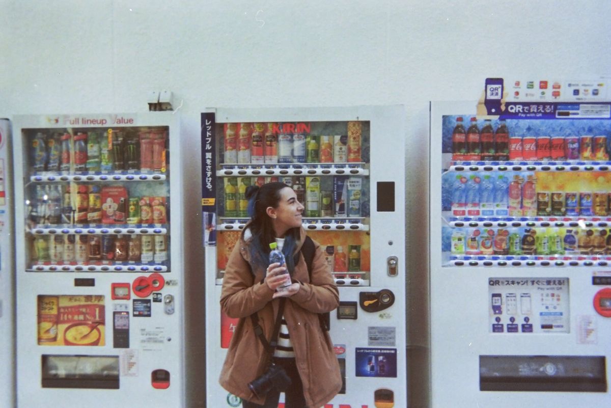 Una ragazza davanti a una fila di distributori automatici