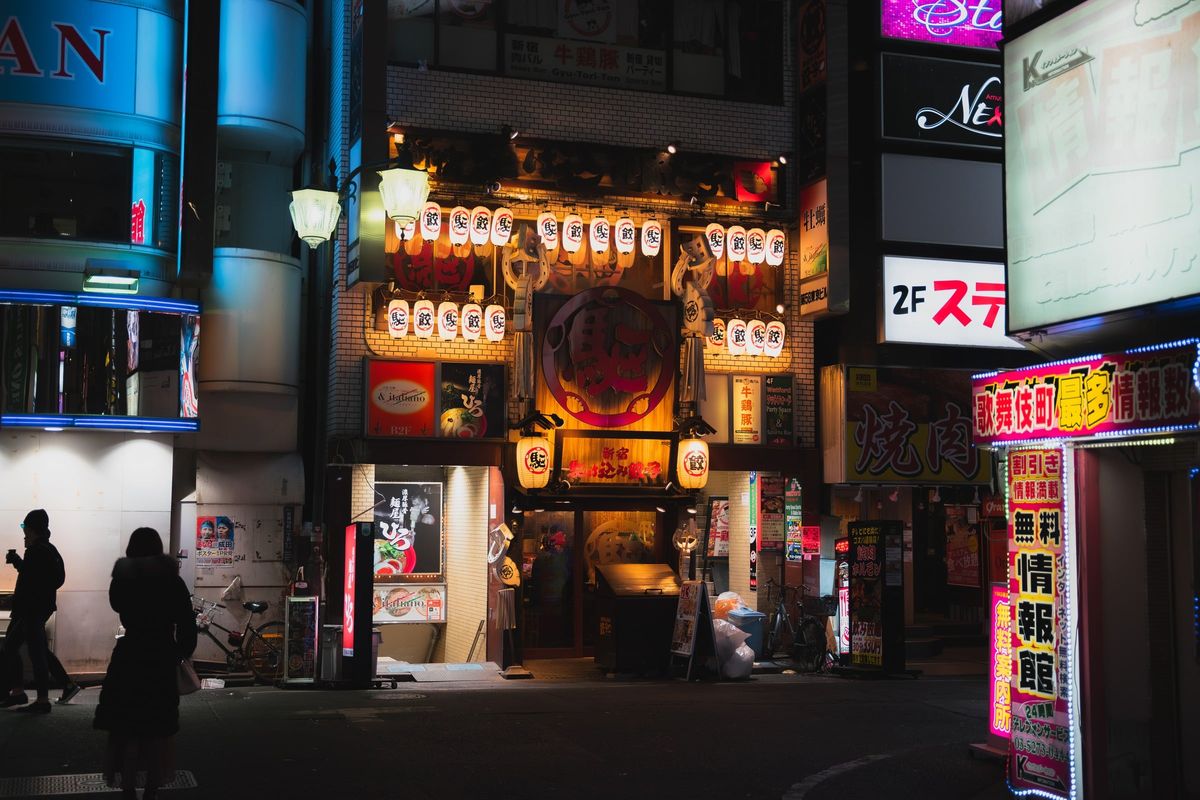 Una strada di Tokyo di notte, con le insegne accese