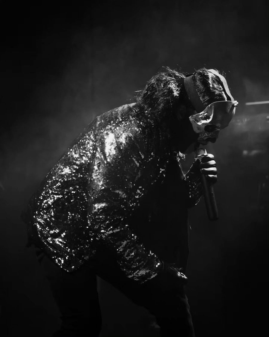 Il cantante dei Lachryma piegato verso il pubblico, in bianco e nero