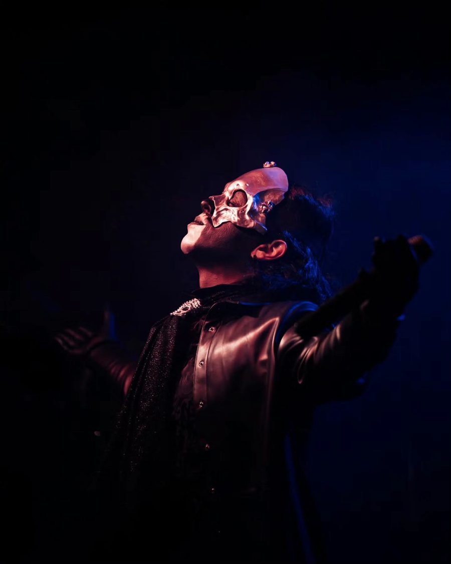 Il cantante dei Lachryma con lo sguardo verso l'alto, tra luce rossa e blu