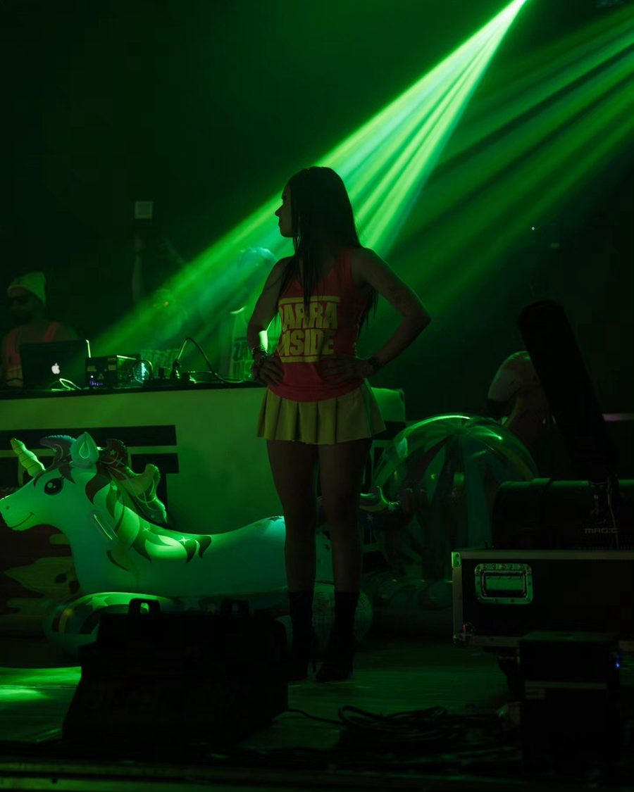 Una ballerina sul palco della festa, tra i laser verdi