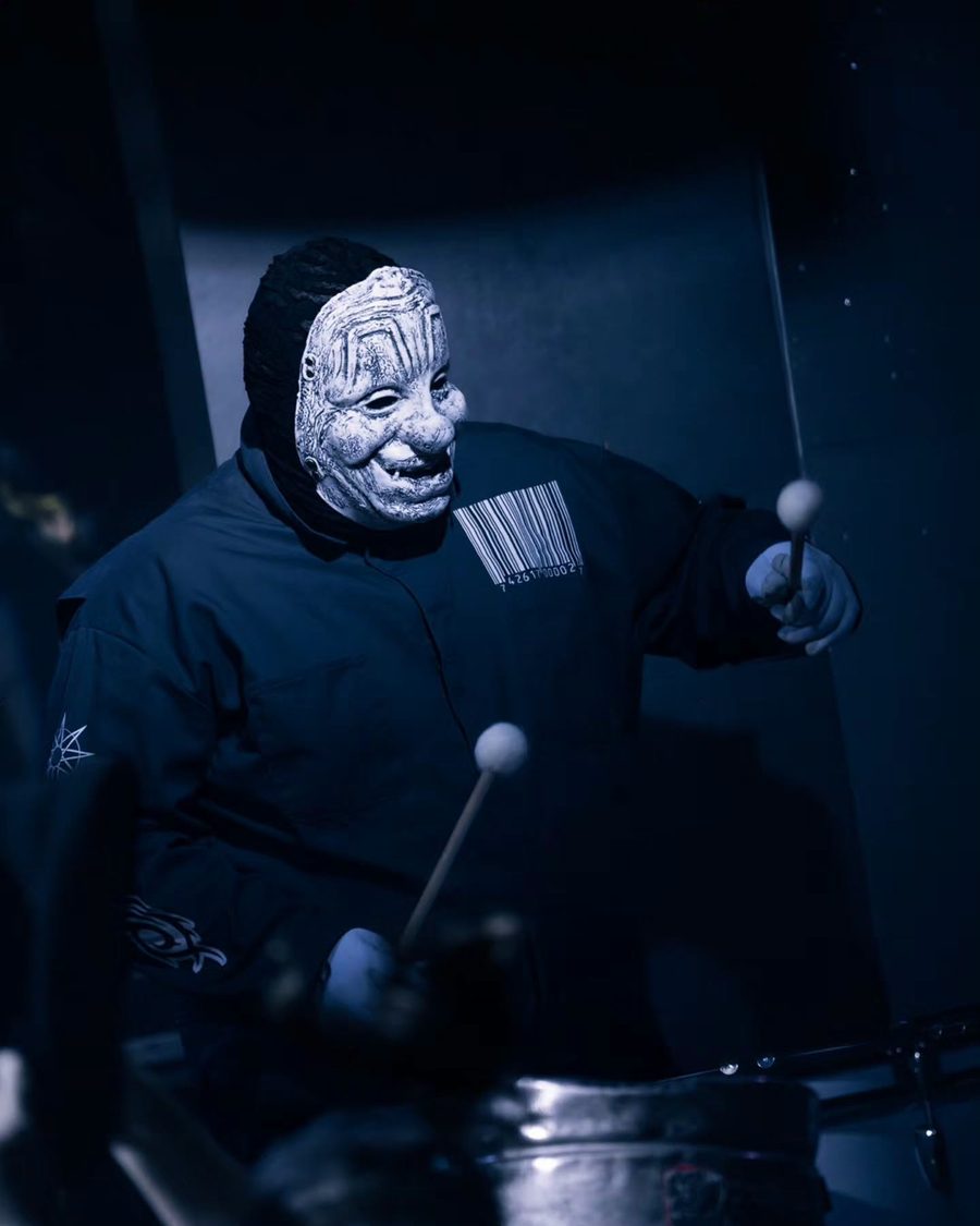 Il percussionista dei Subliminal Verses con le bacchette, in luce blu