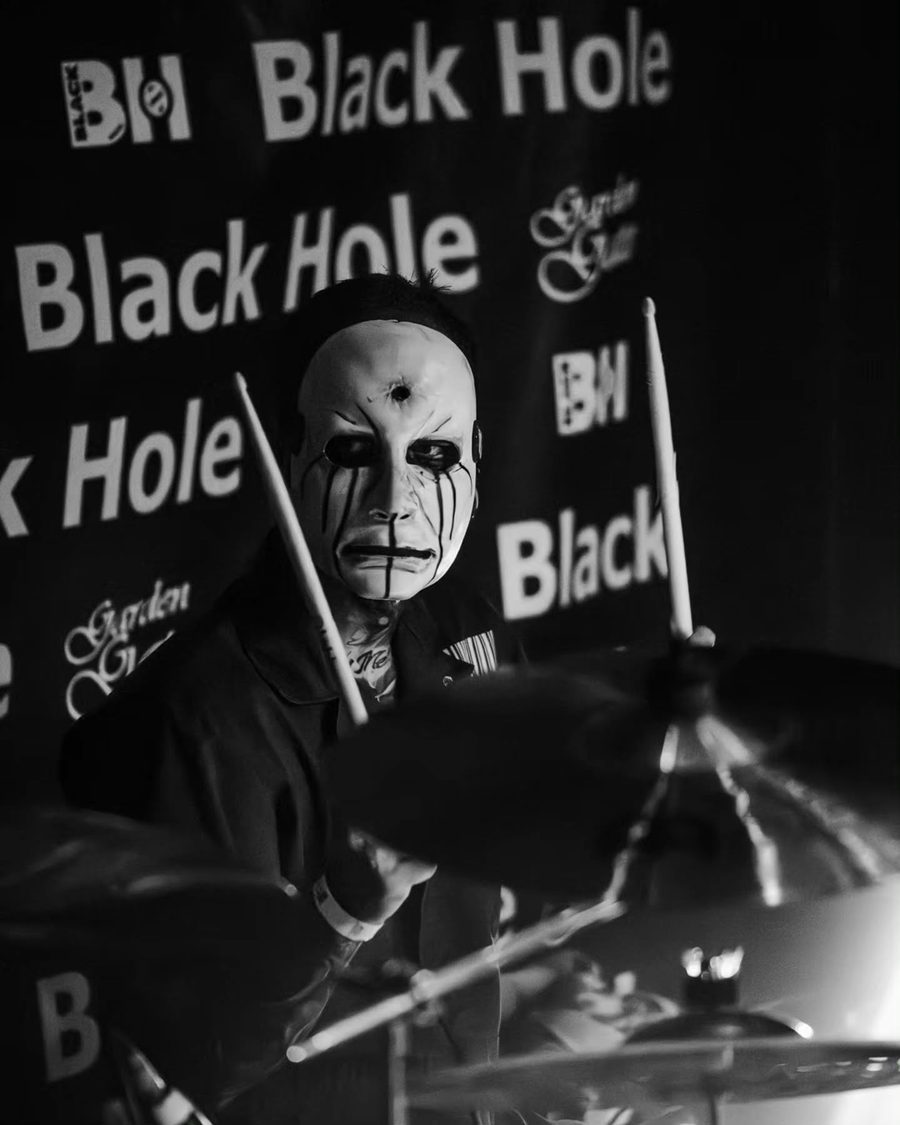 Il batterista dei Subliminal Verses davanti alla scritta Black Hole, in bianco e nero
