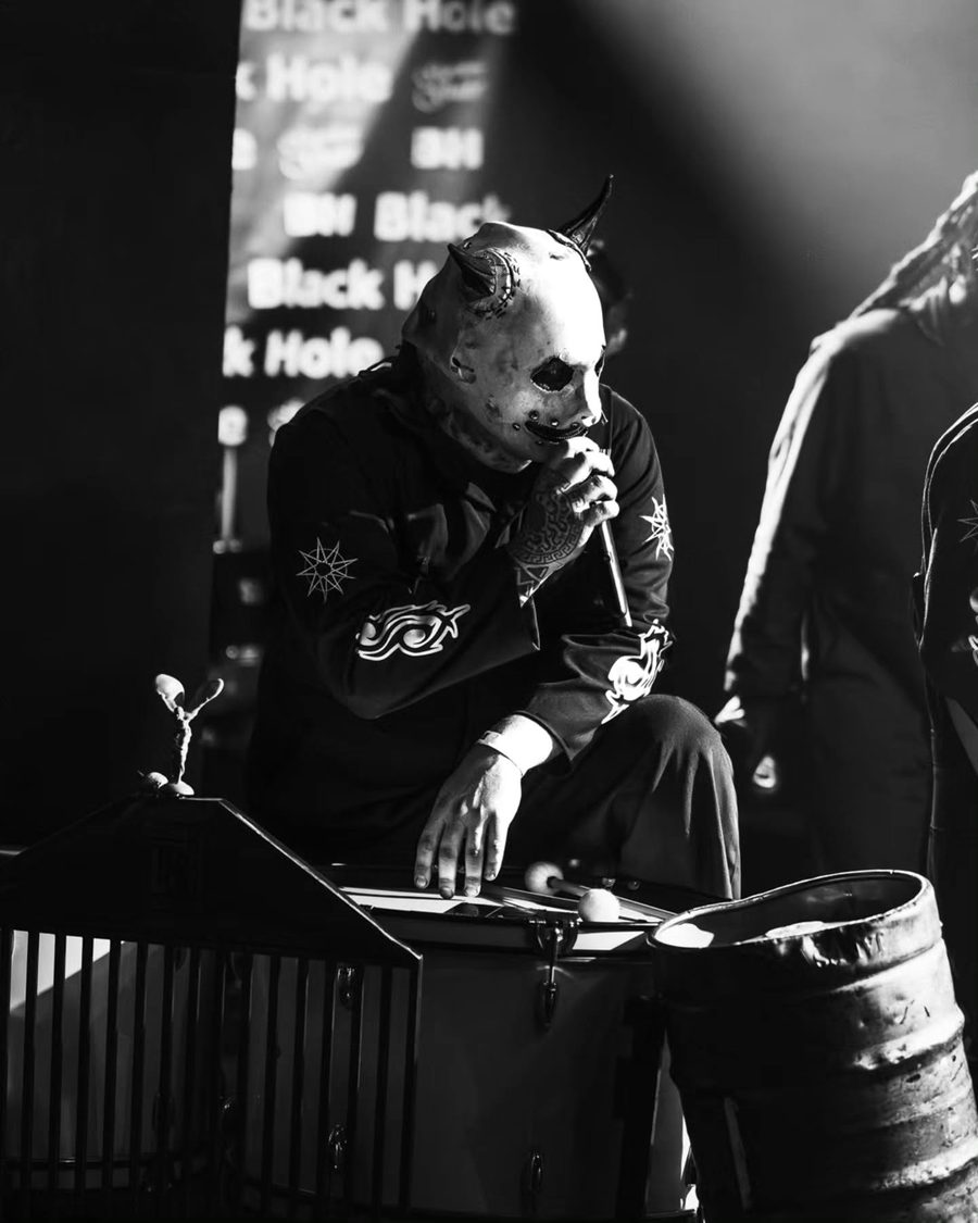 Il percussionista dei Subliminal Verses con la maschera da diavolo sui fusti, in bianco e nero