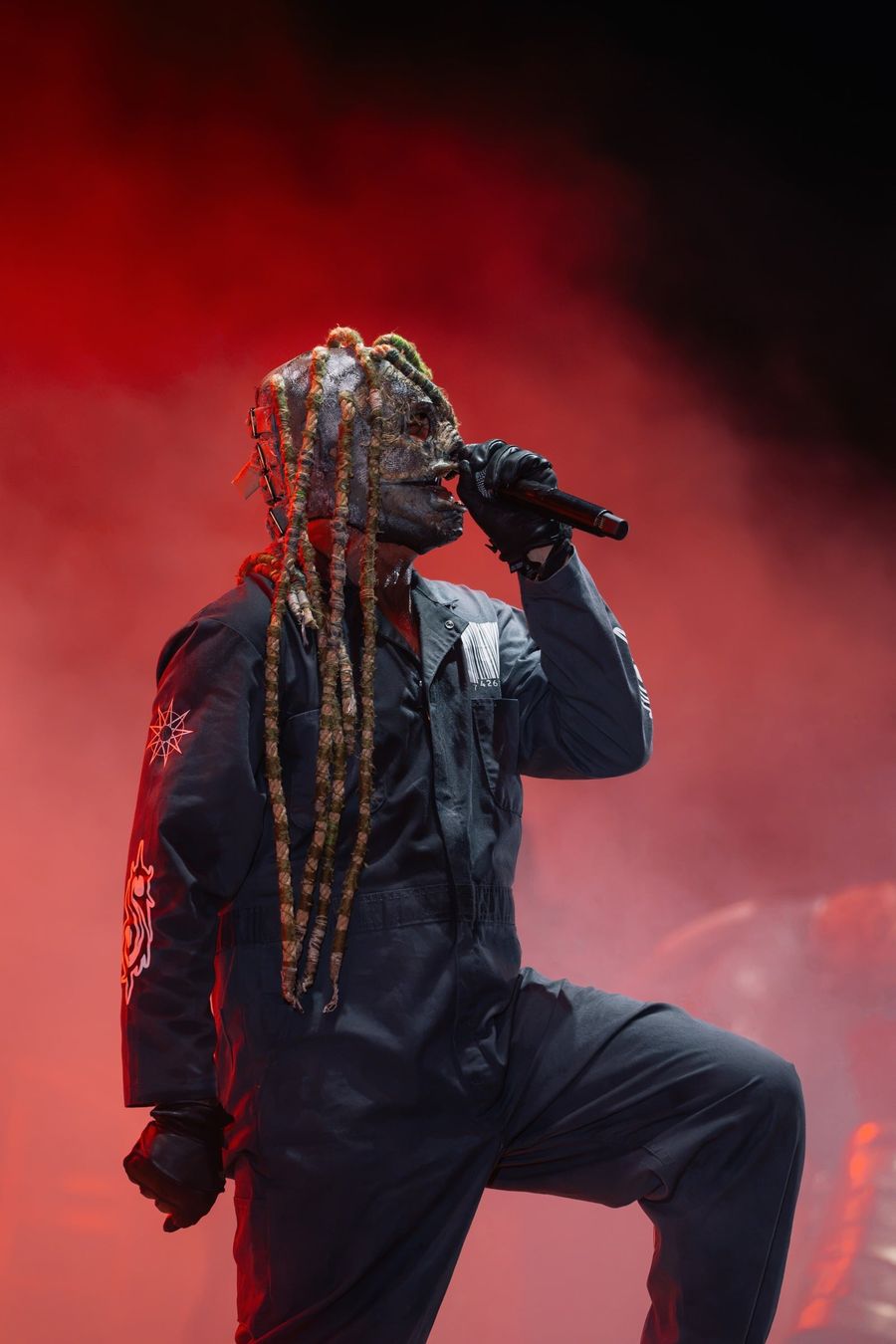 Il cantante dei Subliminal Verses in ginocchio sul palco, sotto una luce rossa