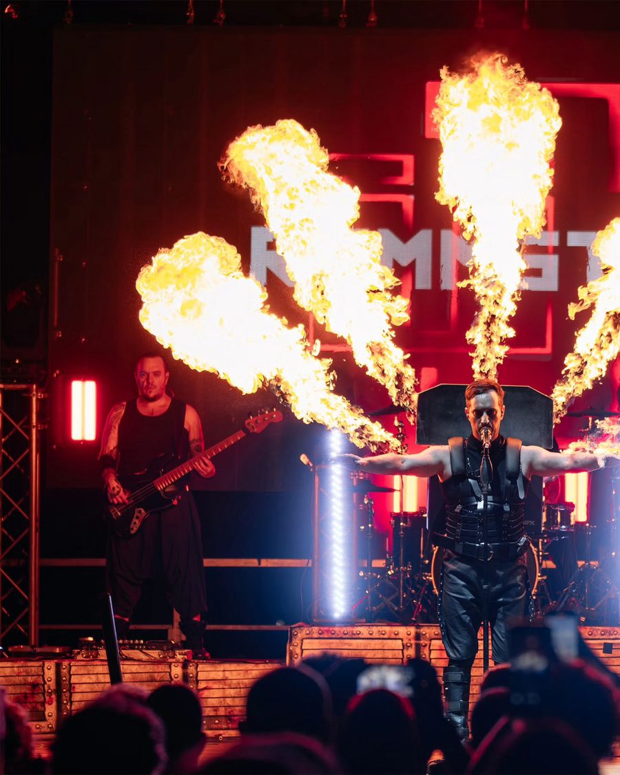 Il cantante degli Übermensch a braccia aperte tra le fiamme, con il nome della band alle spalle