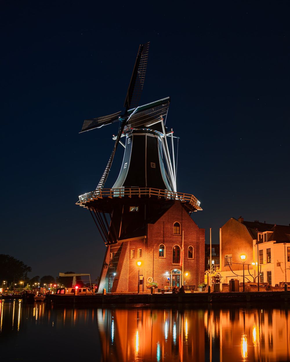 Il mulino di Haarlem di notte, illuminato e riflesso nel canale